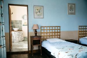 蓬托尔松La Vieille Foulonnière : Chambres d'hôtes & Permaculture的一间卧室配有一张床和镜子