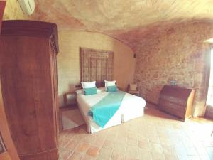 莱斯卡拉Hotel Molí de l'Escala的石头间内一间卧室,配有一张床