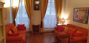 巴黎透明玛莱公寓的客厅配有2张橙色沙发和窗帘