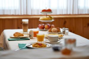 阿罗萨Hotel Garni Sonnenhalde的一张桌子,上面有早餐食品和饮料
