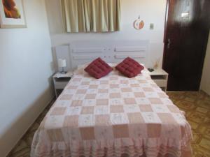 纳塔尔Pousada Zenite的一间卧室配有一张带红色枕头的床