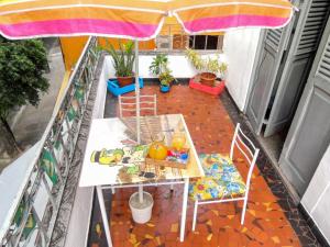 里约热内卢Hostel Recanto de Alegrias em São Cristòvão的阳台配有桌椅和遮阳伞