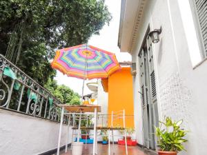 里约热内卢Hostel Recanto de Alegrias em São Cristòvão的房子阳台上的一把色彩缤纷的雨伞