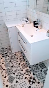 苏佩塔尔Soren-SUN Apt´s的浴室铺有黑白瓷砖地板,配有白色水槽。