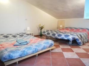 锡耶纳Casa Arcobaleno的铺有瓷砖地板的客房内的两张床