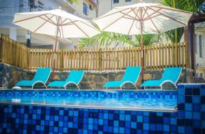 格兰贝伊Azur Paradise的一组椅子和遮阳伞,位于游泳池旁