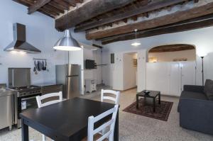 卢卡Il nido nascosto的厨房以及带黑色桌椅的起居室。