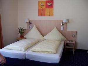 Großostheim兰德加斯托福霍克旅馆的一张位于房间的床,上面有两个枕头