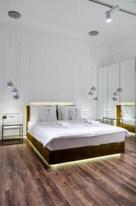 贝尔格莱德Room 25 Belgrade的一间白色卧室,配有一张大床和两张桌子