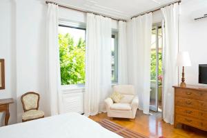 热那亚阿尔巴洛住宿加早餐旅馆的卧室配有床、椅子和窗户。