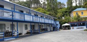WhangaroaWhangaroa Lodge Motel的一座蓝色和白色的建筑,毗邻一座黄色的建筑