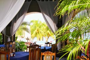 圣地亚哥Suite San Juan 133 Gran Pacifica Resort的一间拥有蓝色桌椅的餐厅,种植了棕榈树