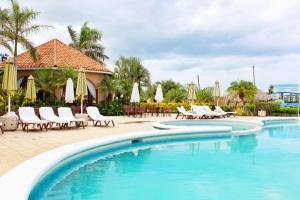 圣地亚哥Suite San Juan 133 Gran Pacifica Resort的度假村内带椅子和遮阳伞的游泳池