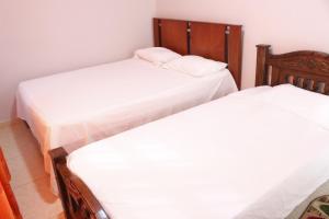 里奥阿查Apartamentos Arpushana的配有白色床单的客房内的两张单人床