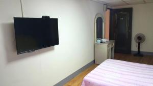 花莲市福大旅馆的卧室配有壁挂式平面电视。