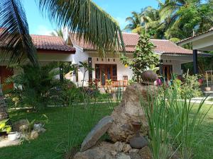 龙目岛库塔Dewi Garden Guesthouse的院子里有大石头的房子