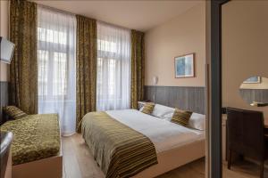 布拉格Hotel Superior Prague的一间卧室配有一张床、一张书桌和一个窗户。