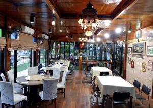 Chai NatSuwanna Riverside的一间带桌椅和吊灯的用餐室