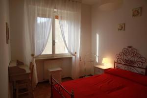卡斯蒂里昂纳·德拉佩Villa Giulia al mare的一间卧室设有红色的床和窗户。