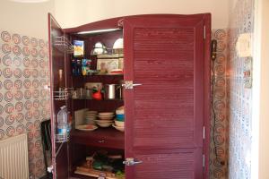 卡斯蒂里昂纳·德拉佩Villa Giulia al mare的开放式的厨房,配有红色橱柜和餐具