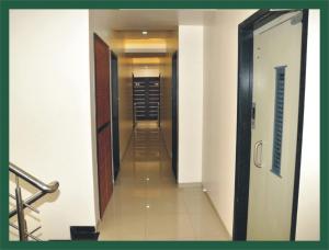 舍地Hotel Shradha Saburi Palace的一条空的走廊,走廊上有一个走廊