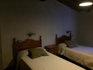 纳瓦孔塞霍LA ANTIGUA TAHONA的一间卧室配有两张床,墙上有两盏灯