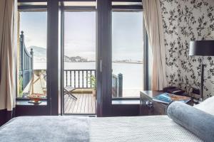 格乔Ercilla Embarcadero Hotel的一间卧室设有一张床,享有阳台的景色