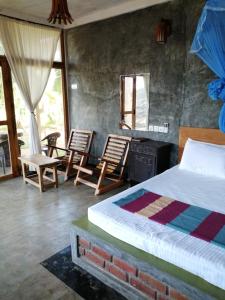 锡吉里亚锡吉里亚天堂湖山林小屋的一间卧室配有一张床、两把椅子和一个壁炉