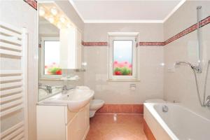 圣克里斯蒂娜Apartments La Baita的一间带水槽、浴缸和卫生间的浴室