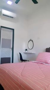 阿罗士打Home2u Alor Setar Homestay的卧室配有粉红色的床和镜子