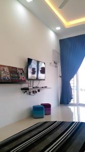 阿罗士打Home2u Alor Setar Homestay的客厅配有电视和蓝色窗帘