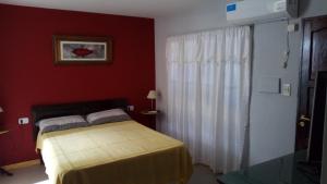 波萨达斯Posadas la hermosa的一间卧室设有一张床和红色的墙壁