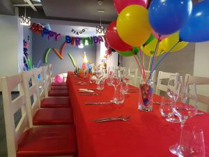 皮特什蒂Net Hotel Pitesti的长红桌子,带气球和酒杯