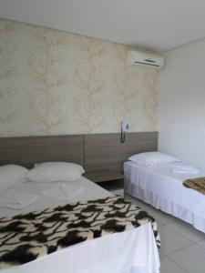 沙佩科Star Hotel的酒店客房带两张床和一面墙