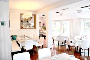 图青Boutique Hotel Reschen的用餐室配有白色的桌子和白色的椅子