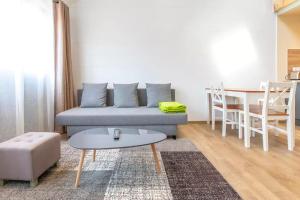 塔卢瓦尔Domaine des Ecuries - Appartements meublés à Talloires的客厅配有沙发和桌子