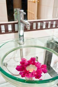 圣克鲁斯Buganvillas Hotel Suites的浴室水槽内装有粉红色的花
