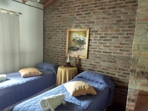 科隆Cabañas del Uru的砖墙客房的两张床