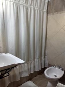科隆Cabañas del Uru的浴室配有淋浴帘和盥洗盆。