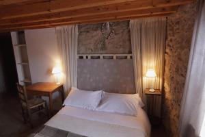 Llo卡尔米克尔住宿加早餐旅馆的一间卧室配有一张带两张桌子和两盏灯的床。
