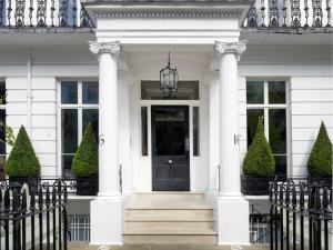 伦敦菲尔姆戴尔16号酒店的一间白色的房子,有黑色的门和柱子