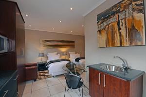 约翰内斯堡萨福隆斯宾馆 的浴室设有一间卧室,配有一张床和一个水槽