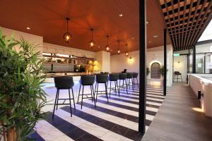 曼谷Villa De Khaosan by Chillax的餐厅内带黑酒吧凳的酒吧