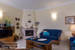 拉戈斯Akivillas Lagos Garden的客厅设有蓝色的沙发和壁炉