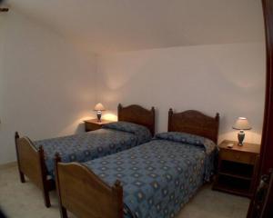 洛克里努拉蒙马酒店的一间卧室设有两张床和两张台灯。