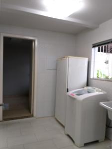 拉热斯Norte Hospedagem的白色的厨房配有冰箱和水槽
