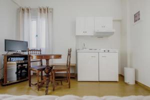 梅加斯·亚洛斯-奈特斯艾米利亚豪华公寓的带桌子和书桌的厨房以及带白色橱柜的厨房。