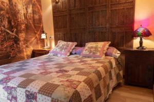 PancarApartamentos Jardines de Llanes的一间卧室配有一张带被子和台灯的床