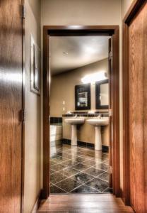 大草原城Grand Inn & Residence- Grande Prairie的浴室内带两个水槽的走廊