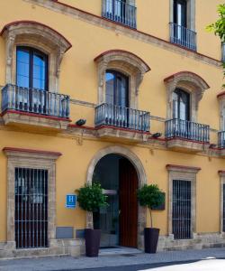 赫雷斯-德拉弗龙特拉Itaca Jerez by Soho Boutique的带阳台和门的黄色建筑